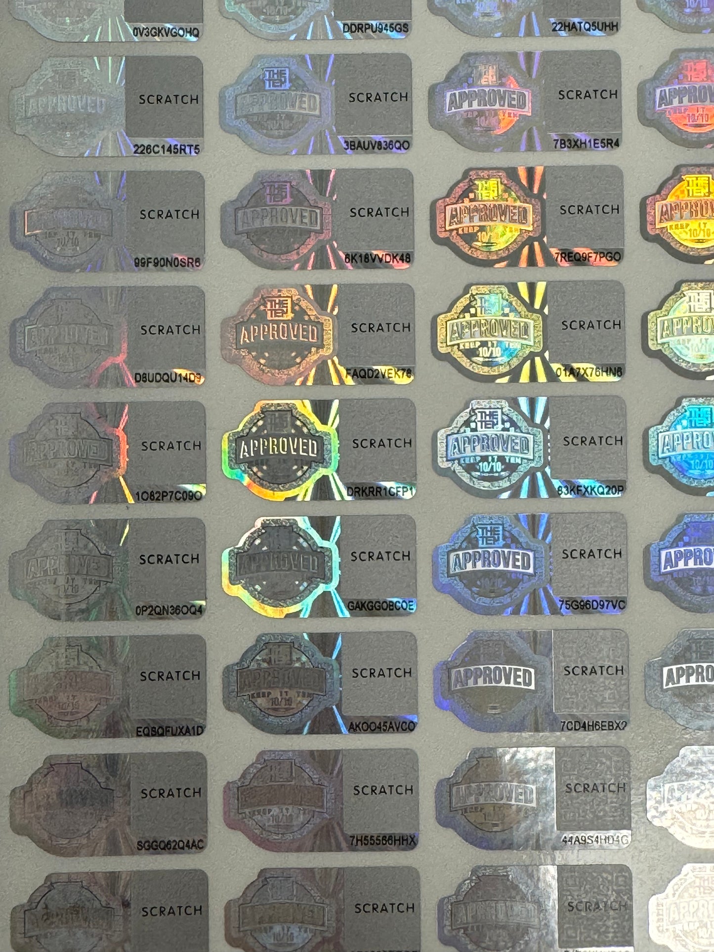 Sheet of holographic stickers with Ten Co 'Approved' and 'Scratch' text | hologram